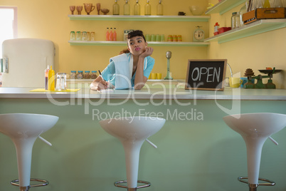 Waitress standing at counter in restaurant