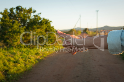 Hand hitchhiking on a sunny day