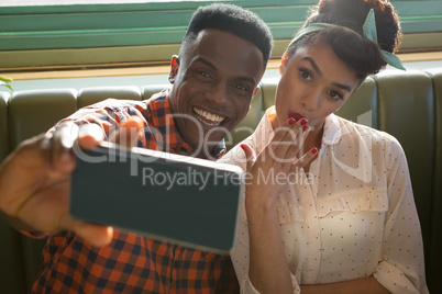 Couple taking selfie with mobile phone in restaurant