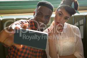 Couple taking selfie with mobile phone in restaurant