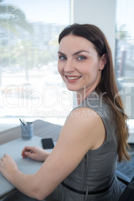 Portrait of confident female executive sitting at desk