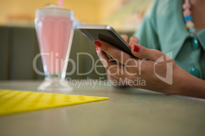 Woman sitting in restaurant using her mobile phone