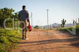 Man standing with petrol can at countryside
