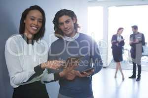 Male and female executives discussing over digital tablet