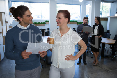 Male and female executives discussing over document