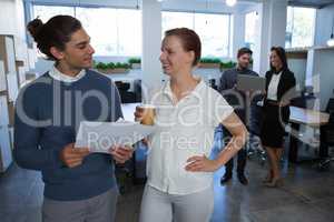 Male and female executives discussing over document