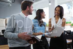 Executives smiling and discussing over laptop