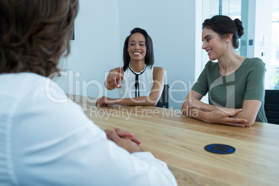 Group of executives discussing on project sitting around table in office