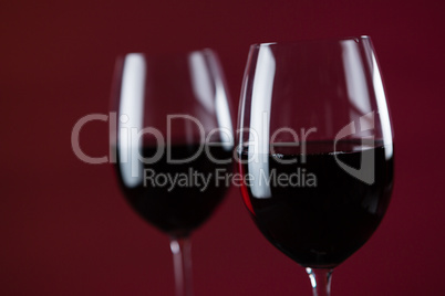 Two wine glasses against red background