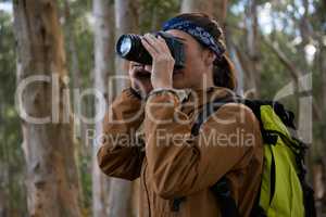 Hiker woman clicking a photo in forest