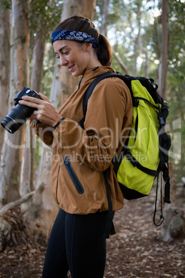 Young woman with backpack standing in the forest