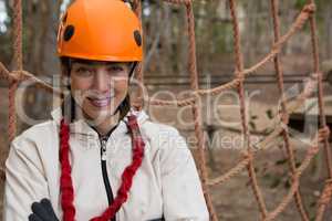 Portrait of smiling woman posing near a rope fence in the forest