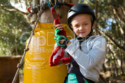 Little girl wearing helmet getting ready to ride zip line