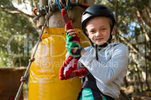 Little girl wearing helmet getting ready to ride zip line