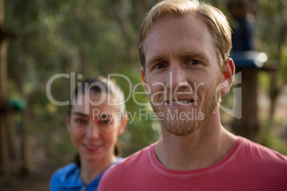 Happy man and woman standing in forest