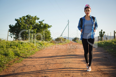 Woman walking on dirt track in countryside