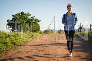 Woman walking on dirt track in countryside