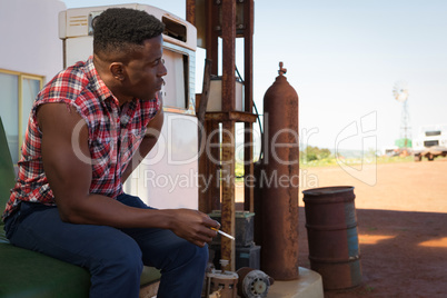 Man smoking cigarette at petrol pump station