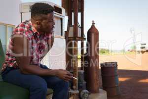 Man smoking cigarette at petrol pump station