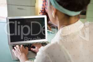 Woman using laptop in restaurant