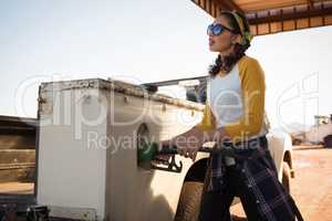 Woman filling petrol in car at petrol pump