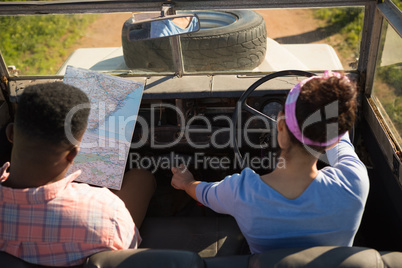 Couple looking at map while driving a car