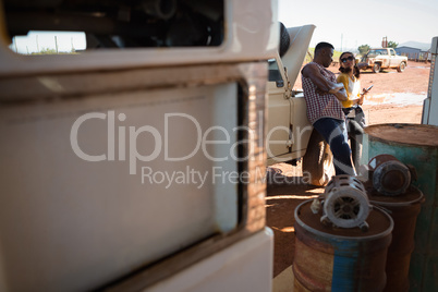 Couple interacting with each other at petrol pump station