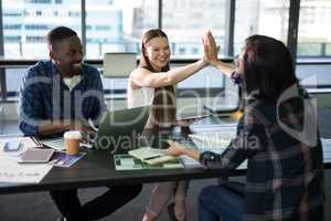 Happy executives giving high five to each other