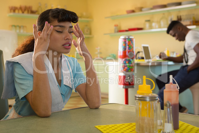 Waitress suffering from headache in restaurant