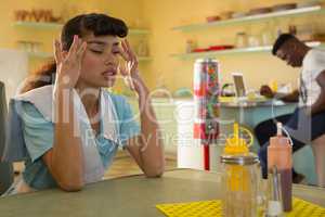 Waitress suffering from headache in restaurant