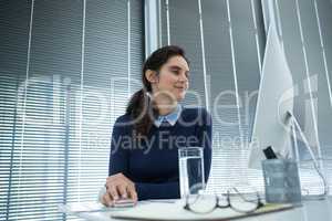 Female executive working on desktop pc at desk