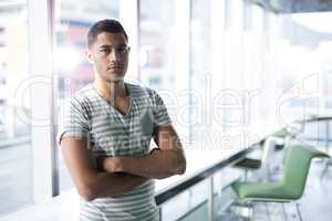 Portrait of male executive standing with arms crossed