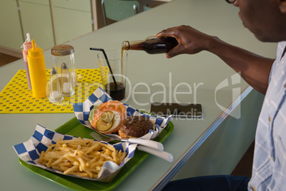 Man pouring drink into glass at restaurant