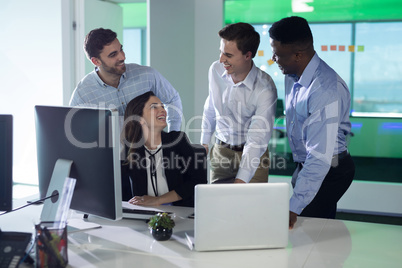 Executives interacting while working on personal computer