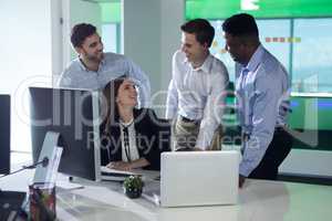 Executives interacting while working on personal computer