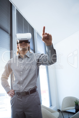 Male executive gesturing while using virtual reality headset