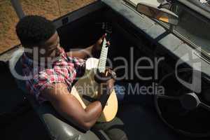 Man playing guitar in car