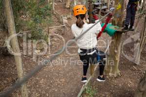 Hiker woman going down a zip line in the forest