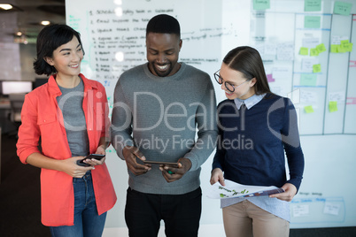 Male and female executives using digital tablet in office