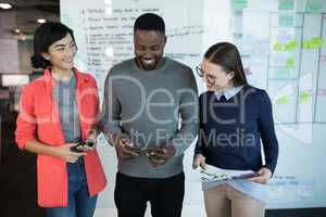 Male and female executives using digital tablet in office