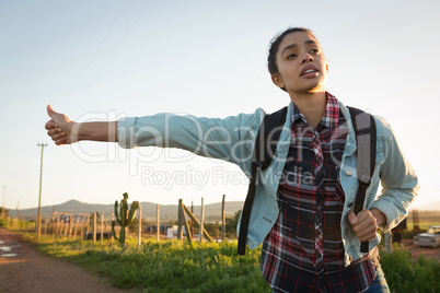 Woman hitchhiking on a sunny day