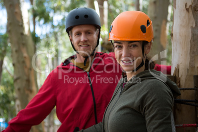 Smiling hiker couple wearing helmet standing in the forest during daytime