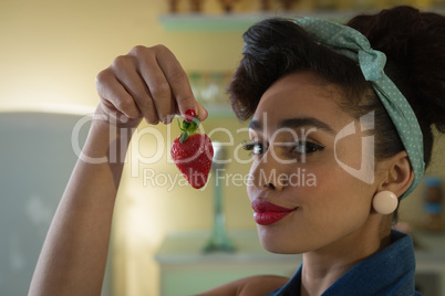 Woman having a strawberry at home