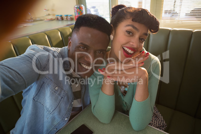 Smiling couple sitting on couch having fun in restaurant