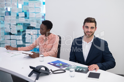 Male and female executives looking at graph