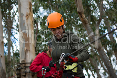 Hiker couple holding zip line cable in the forest