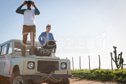 Man looking through binoculars at countryside