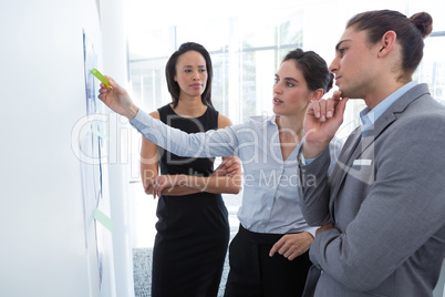 Business colleagues discussing over whiteboard