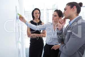 Business colleagues discussing over whiteboard