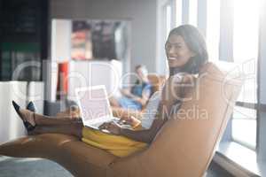 Portrait of female executive using laptop